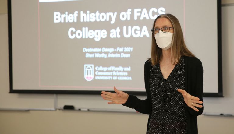 Dean Worthy in front of screen stating Brief history of FACS College at UGA