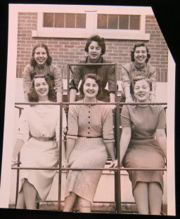Six women in front of house